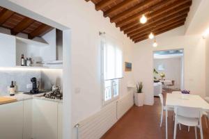 a kitchen and dining room with white cabinets and a table at San Niccolò City Walls Garden in Florence