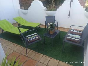 マルベーリャにあるCasa adosada La Reserva de Marbellaのパティオ(椅子3脚、芝生の上にテーブル付)