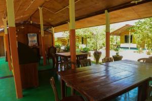 a dining room with wooden tables and chairs at Sunntop Cabana in Trincomalee