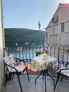 a balcony with a table and chairs and a view of the water at Apartment Alex in Kotor