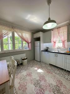 a kitchen with white cabinets and a table and chairs at COUNTRY HOME in Trabzon