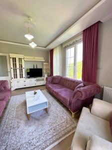 a living room with a purple couch and a table at Country Home in Trabzon