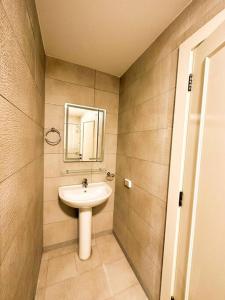 La salle de bains est pourvue d'un lavabo et d'un miroir. dans l'établissement central apartment for rent 28, à Umm Uthainah