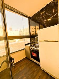 Il comprend une petite cuisine équipée d'un réfrigérateur et d'une cuisinière. dans l'établissement central apartment for rent 28, à Umm Uthainah