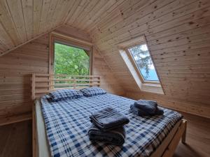 um quarto com uma cama num chalé de madeira em Počitniška hiša Mlekarna Grant em Grahovo