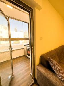 a living room with a couch and a large window at central apartment for rent 28 in Umm Uthainah