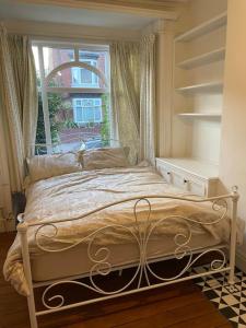 een bed in een slaapkamer met een raam bij Lovely 3 bedroom house-Heart of Moseley Village in Birmingham