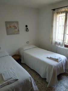 2 camas en una habitación blanca con ventana en Les oliveres de l'Empordà, en Bellcaire dʼEmpordà