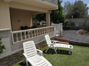 dos sillas blancas sentadas en el césped en un patio en Les oliveres de l'Empordà, en Bellcaire dʼEmpordà