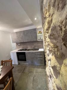 una cocina con una pared de piedra junto a una mesa en Totò’s house, en Zaccanopoli
