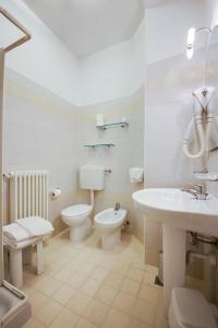 a white bathroom with a toilet and a sink at Aris Hotel in Bellaria-Igea Marina
