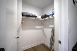 ロサンゼルスにあるModern Apartment in Studio Cityのベッド1台とクローゼットが備わる小さな客室です。