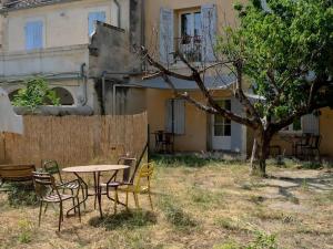 un tavolo e sedie in un cortile accanto a un edificio di maison Ravaux D a Arles