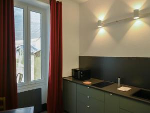 a kitchen with a black counter and a window at maison Ravaux D in Arles