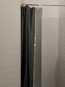 una doccia con tenda nera in bagno di maison Ravaux D a Arles