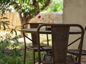 un tavolo in legno e 2 sedie intorno a un tavolo di maison Ravaux D a Arles