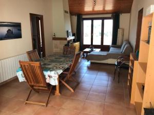 sala de estar con mesa, sillas y sofá en Casa Mar y Piscina (solo familias), en Sant Cebrià de Vallalta