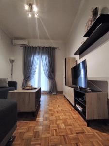 salon z telewizorem i drewnianą podłogą w obiekcie Central Cosy apartment in Corfu town w mieście Ágios Rókkos