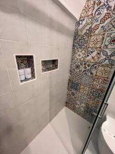 baño con ducha con azulejos en la pared en Casa Mirabilis 44, en Ostuni