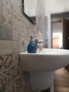 baño con lavabo blanco y azulejos en Lory, en Elice