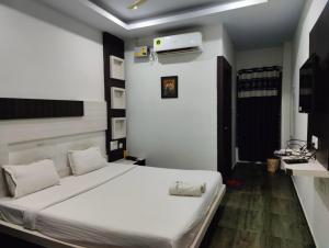 a bedroom with a bed with white sheets at Hotel Cipron Inn in Udala