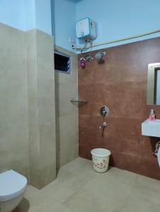 a bathroom with a shower and a toilet and a sink at Hotel Cipron Inn in Udala