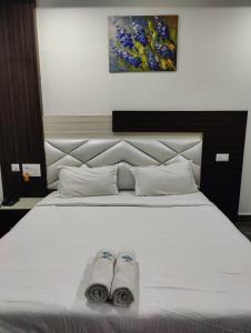 a bedroom with a bed with two slippers on it at Hotel Cipron Inn in Udala