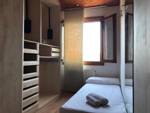 a small room with a bed and a window at Casa Mar y Piscina (solo familias) in Sant Cebrià de Vallalta +39 photos