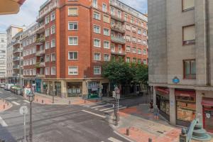 eine leere Stadtstraße mit einem großen Backsteingebäude in der Unterkunft Piso reformado en Bilbao centro in Bilbao