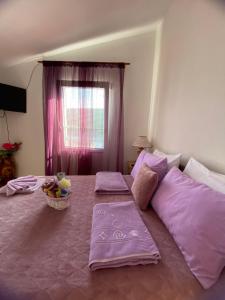 uma cama grande com lençóis roxos e uma janela em Apartment Alex em Kotor