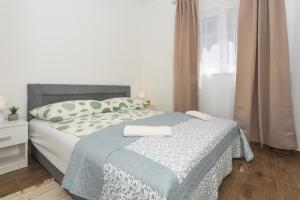 a bedroom with a bed with a blue blanket at Mara in Šibenik