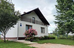 a small white house with a black roof at Kuća za odmor Miriam in Otočac