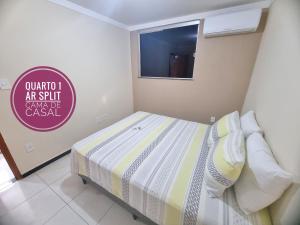 1 dormitorio con 1 cama con un cartel en la pared en TH Flats GV en Governador Valadares