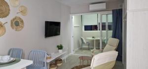 Una sala de estar con una mesa y sillas y un televisor. en ESTUDIOS DANIEL y MARTA, en La Mata