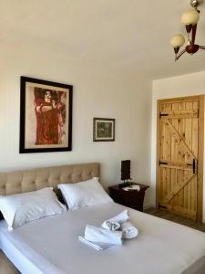 a bedroom with a bed with two towels on it at Rahoni Park & Suites in Dhërmi