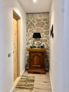 a hallway with a table with a lamp on it at Rahoni Park & Suites in Dhërmi