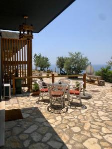 a patio with a table and chairs on a patio at Rahoni Park & Suites in Dhërmi