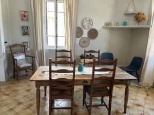 a dining room with a wooden table and chairs at Maison mitoyenne dans quartier calme in Saleich