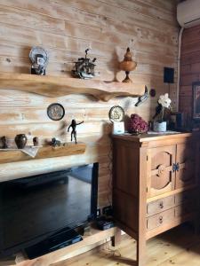 a room with a wooden wall with clocks and a fireplace at Rahoni Park & Suites in Dhërmi