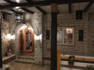 a stone building with an archway and a door at Rahoni Park & Suites in Dhërmi