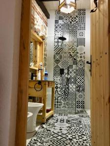 a bathroom with a shower with a black and white tile floor at Rahoni Park & Suites in Dhërmi