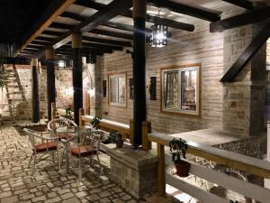 a patio with a table and chairs in a building at Rahoni Park & Suites in Dhërmi