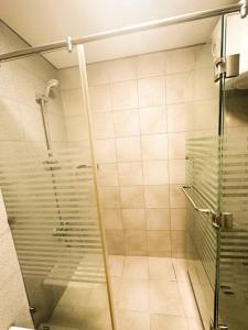 a shower with a glass door in a bathroom at central apartment for rent 24 in Umm Uthainah
