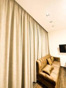 a living room with a couch and a curtain at central apartment for rent 24 in Umm Uthainah