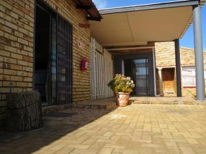 a porch of a brick building with a potted plant at Kgatholoha Guest House in Klerksdorp