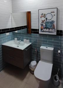 Apartamento Arenita في Puerto: حمام به مرحاض أبيض ومغسلة