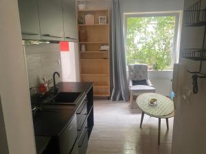 a kitchen with a sink and a refrigerator and a window at Secret Garden by Arder in Gdynia