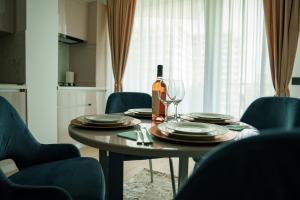 a dining room table with a bottle of wine and glasses at Valleta Sea View Infinity Beach Pool&Spa in Mamaia Nord