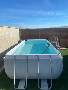 Eine große Badewanne stand auf dem Rasen neben einem Zaun. in der Unterkunft Casita la Loma in Cádiz + 6 Fotos