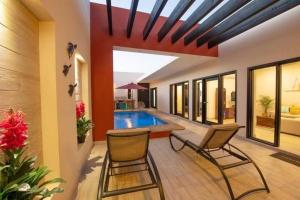 a pool in a house with two chairs and a swimming pool at Casa Amor! Completely Private Home & Pool, Close Beach, Bikes in Loreto